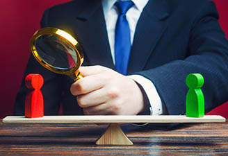 Man with magnifying glass and red and green wooden pieces